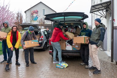 OPORA-vrijwilligers laden hulpgoederen uit een auto in Oekraïne.